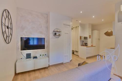 un salon avec un lit et une télévision sur un mur dans l'établissement Carré d'Or 2p à deux pas de la mer, à Nice