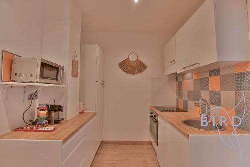 une petite cuisine avec un évier et un micro-ondes dans l'établissement Carré d'Or 2p à deux pas de la mer, à Nice