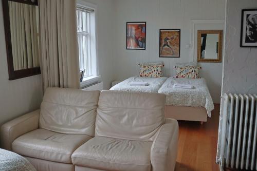 sala de estar con sofá y 2 camas en Ragna's apartment downtown. en Reikiavik
