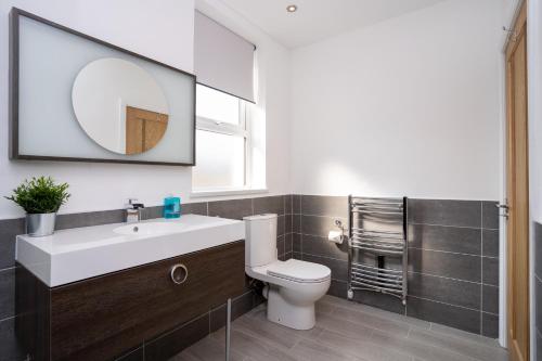 y baño con lavabo, aseo y espejo. en Luxurious 1 Bedroom Central Apartment. Sleeps 4, en Blackpool