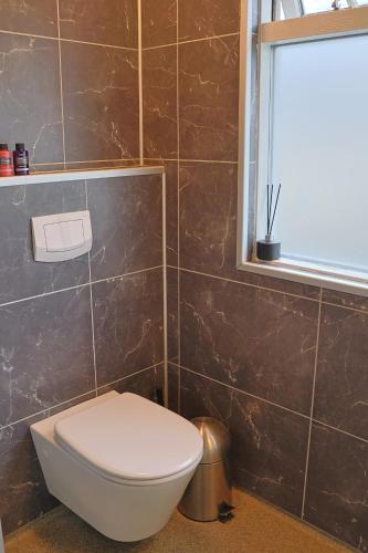 a bathroom with a toilet and a window at Floki's apartment downtown. in Reykjavík