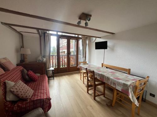 un salon avec une table et un canapé dans l'établissement Le Génépi, à Taninges