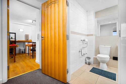 a bathroom with a toilet and a yellow door at Central Flat Pool Table Balcony in Sheffield