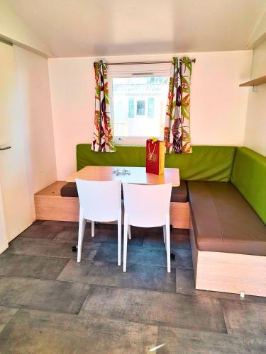 Cette petite chambre comprend une table et des chaises. dans l'établissement Le C24 - Charmant bungalow tout équipé pour 4 avec TV, à Boofzheim