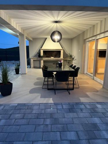 a patio with a table and chairs and a fireplace at Kuća za odmor 'Luca' in Ljubuški