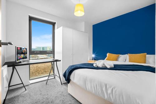 a bedroom with a blue wall and a bed and a desk at Central Flat Pool Table Balcony in Sheffield