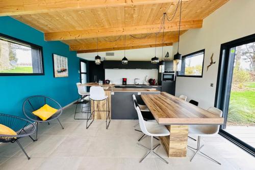 une cuisine avec une table et des chaises en bois dans l'établissement Lodge Aigrette - Laïta Guidel, à Guidel