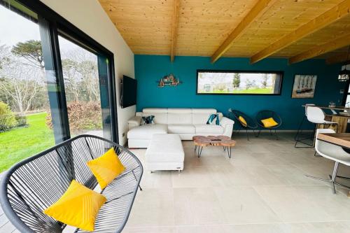 - un salon avec un canapé blanc et des oreillers jaunes dans l'établissement Lodge Aigrette - Laïta Guidel, à Guidel