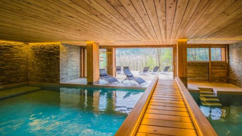 - une piscine avec des chaises dans une maison dans l'établissement Savoielac - La Clusaz- Piscine intérieure : Chalet Viking, à La Clusaz