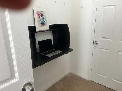una estantería negra con un ordenador portátil en la pared en Disney Themed House Free Heated Pool close Disney 5br 9bd, en Orlando