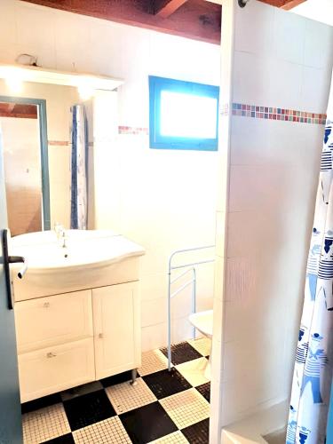 une salle de bain avec un lavabo et un miroir dans l'établissement Maison accueillante à Vielle-Saint-Girons avec jardin et cheminée, à Vielle-Saint-Girons