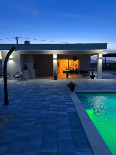 a house with a swimming pool at night at Kuća za odmor 'Luca' in Ljubuški