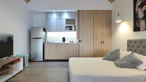 a room with a bed and a kitchen with a refrigerator at Tree House, Cabaña privada con Jacuzzi in Guatapé