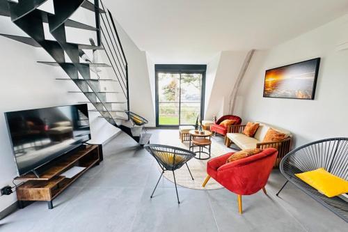 - un salon avec des chaises rouges et une télévision dans l'établissement Avocette élégante - Laïta Guidel, à Guidel