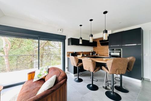 une cuisine avec une table et des chaises dans une pièce dans l'établissement Linotte mélodieuse-Laïta Guidel, à Guidel