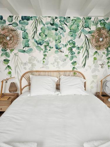 une chambre avec un lit avec un papier peint fleuri dans l'établissement Maison Brizon collection Pepeaz, à Tours