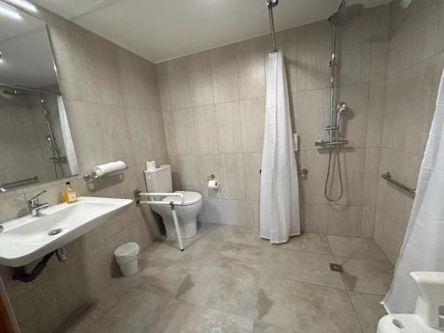 a bathroom with a toilet and a sink and a shower at Logis Hotel De La Clape in Narbonne-Plage
