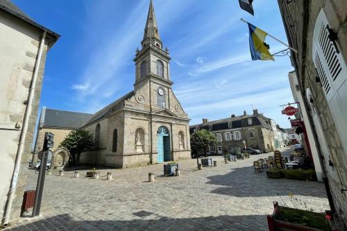 an old church with a clock tower on a street at Feet in the water breathtaking 180 sea view! in Port-Louis