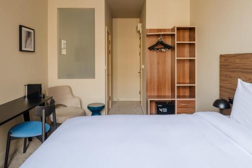 a bedroom with a large white bed and a desk at Sonder The Gilbert in London