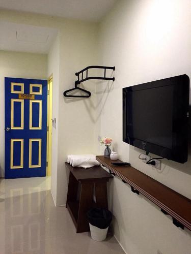 a living room with a flat screen tv on a wall at The Pho Thong Phuket in Phuket