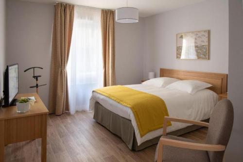 une chambre avec un lit avec une couverture jaune dessus dans l'établissement DOMITYS L'AIGRETTE BLEUE, à Abbeville