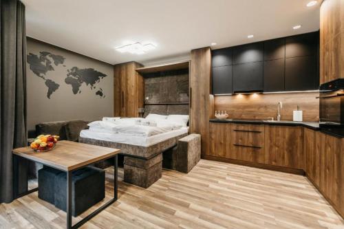 ein Schlafzimmer mit einem Bett und einem Tisch sowie eine Küche in der Unterkunft Apartament B Park City in Ostrowo