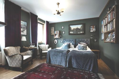 a bedroom with two beds and a chair at Hotell Gästis in Varberg