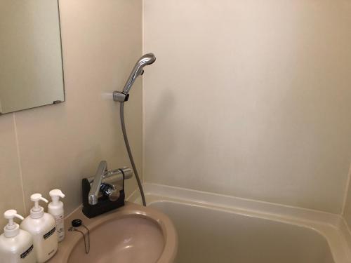 W łazience znajduje się umywalka i prysznic. w obiekcie HOTEL GATE 88 w mieście Naruto