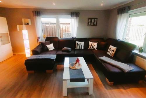 uma sala de estar com um sofá e uma mesa de centro em Ferienhaus Mooi Utblick - a85805 em Rechtsupweg
