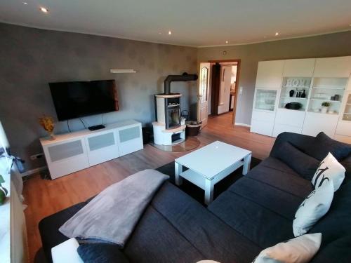 uma sala de estar com um sofá e uma televisão em Ferienhaus Mooi Utblick - a85805 em Rechtsupweg