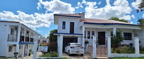 a white car parked in front of a white house at Pousada Felix in São Gabriel