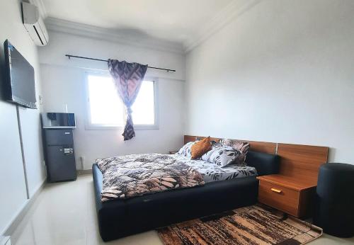 a small bedroom with a bed and a window at Chambres meublées Avenue Cheikh Anta Diop in Dakar