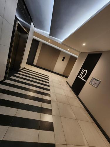 a hallway of an office building with a no sign on the floor at 10th floor, Unit 1008, in The Capital Trilogy, overlooking Sun Time Square in Pretoria