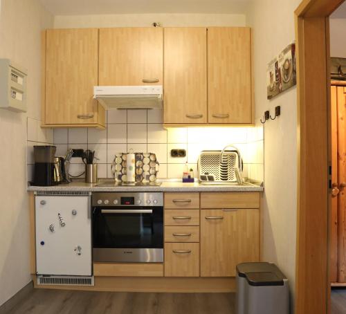 a kitchen with wooden cabinets and a stove top oven at Walther Sundweg 14 in Heiligenhafen