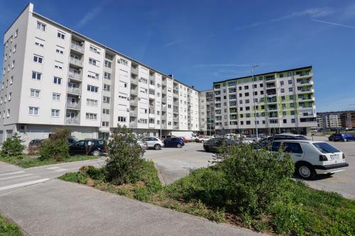 a parking lot in front of a large building at Apartman Andrea in Lukavica