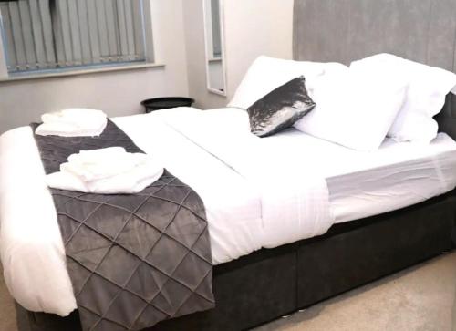 a bed with white sheets and black and white pillows at Charming 1-Bed Apartment in Leeds in Leeds
