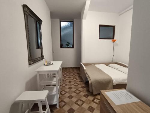 Habitación pequeña con cama, mesa y ventana en Villa Stoia, en Ocna Sibiului