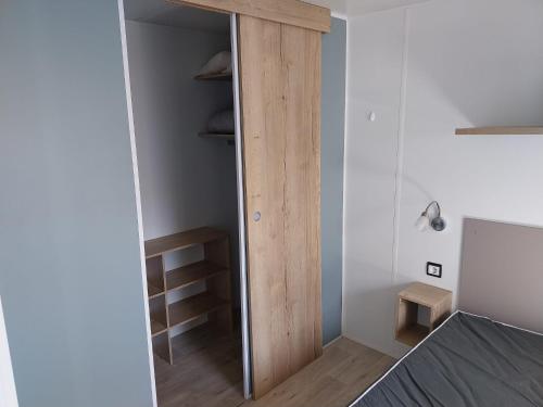 a bedroom with a closet with a glass door at Mobil Home in Valras-Plage