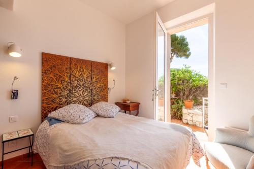 a bedroom with a large bed with a large window at L'aiguade - Cassis in Cassis
