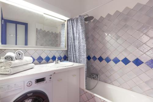 a bathroom with a washing machine and a sink at L'aiguade - Cassis in Cassis
