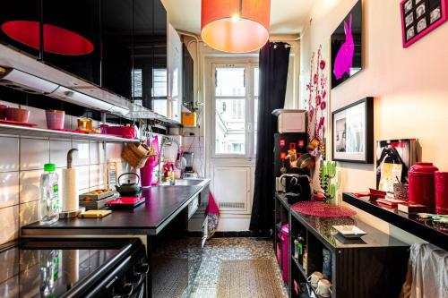 une grande cuisine avec un comptoir et une fenêtre dans l'établissement GuestReady - Apt lumineux face au Musée D'Orsay, à Paris