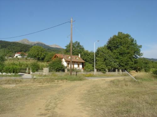 a dirt road with a house in the background at The Lake's House in Kryonérion