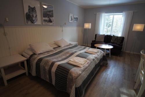 a bedroom with a bed and a chair and a window at Mannflogården Bed & Breakfast , Sälenfjällen in Sälen