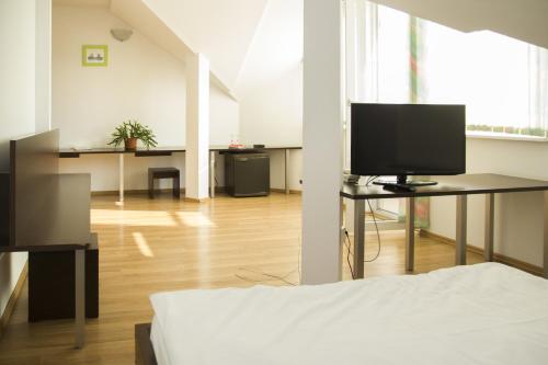 a room with a bed and a tv and a desk at Villa Grande in Iaşi