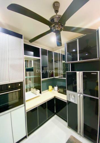 a kitchen with green cabinets and a ceiling fan at 4 Bedrooms Homestay, Fully Aircond in Sendayan by D'KAY HOMES I 10-15 pax in Seremban
