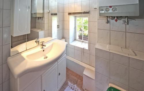a white bathroom with a sink and a window at 1 Bedroom Cozy Home In Jabel in Jabel