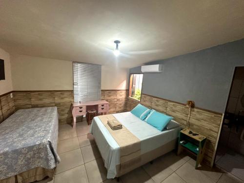 sypialnia z 2 łóżkami, stołem i oknem w obiekcie Casa di Vó w mieście Mucugê