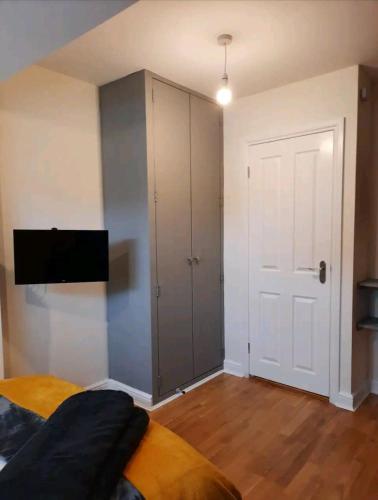 ein Schlafzimmer mit einem weißen Schrank und einer Tür in der Unterkunft Double Room with ensuite close to silverstone in Whittlebury