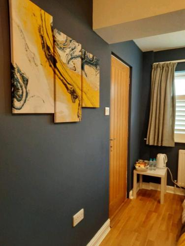 a room with three paintings on the wall at Double Room with ensuite close to silverstone in Whittlebury