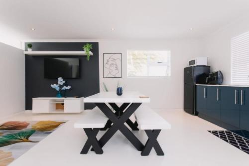 a dining room with a white table and a tv at DMK GUESTHOUSE 2 in Cape Town